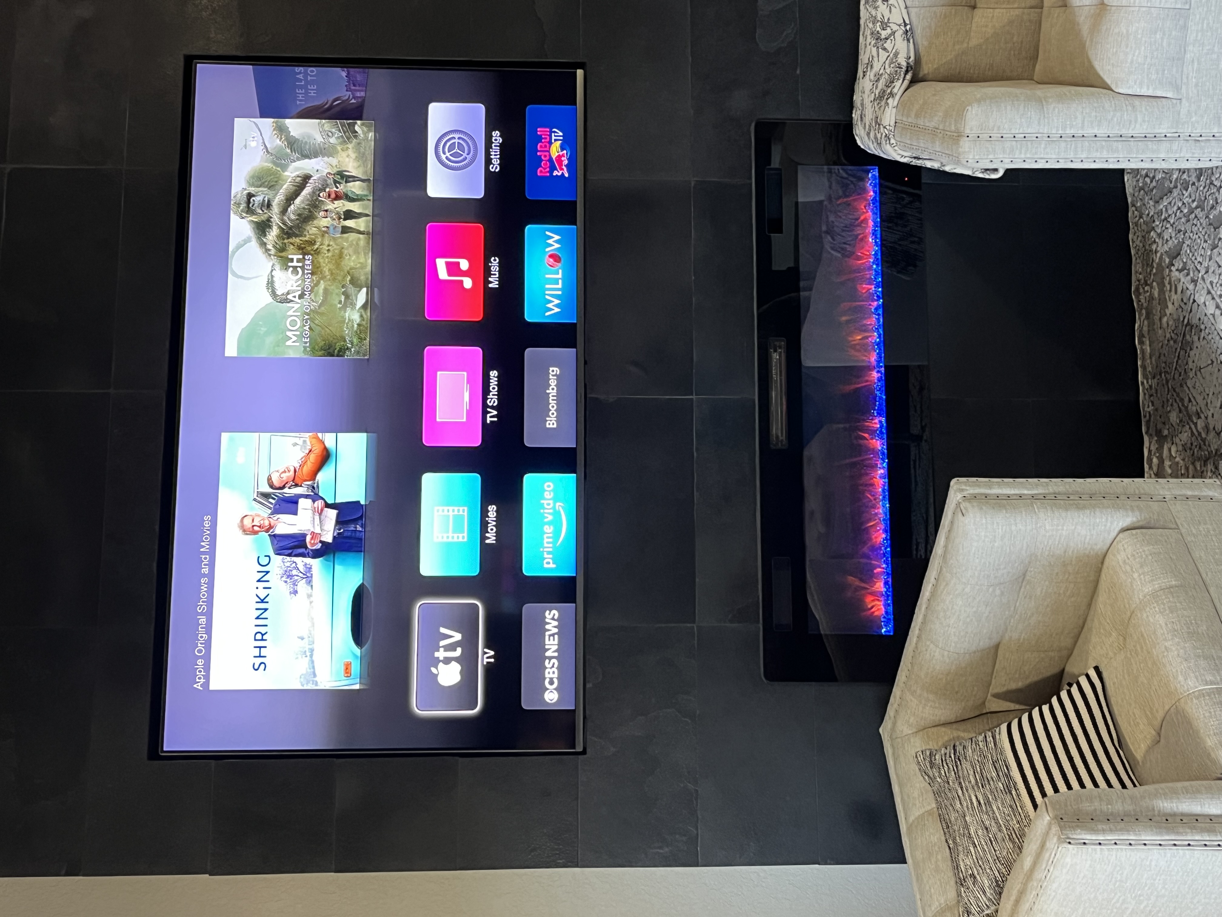 TV mounted above fireplace with flames
